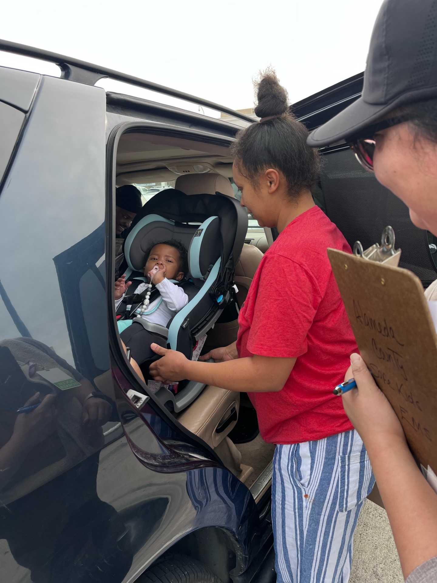 mother and child properly putting car seat in car